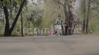 可爱的男孩穿着鲜艳的衣服在河边的公园里<strong>滑</strong>旱冰。 户外休闲。 孩子一个人玩